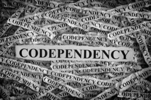 Torn pieces of paper with the words Codependency