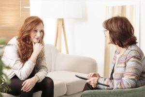 Smiling woman talking to a wellness coach to find motivation to achieve physical health goals