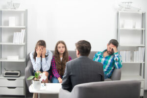 Couple with child teenager discussing problems in family with family psychologist. Parental concept