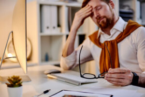 Tired businessman rubbing his forehead.